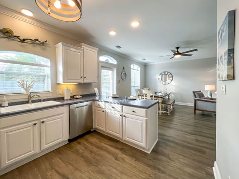 The spacious kitchen opens to the dining area. The rear door leads to the grill