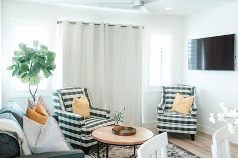 Fresh, light-filled living room with stylish seating, a large TV, and a polished modern design—perfect for relaxing, watching movies, or spending time together.