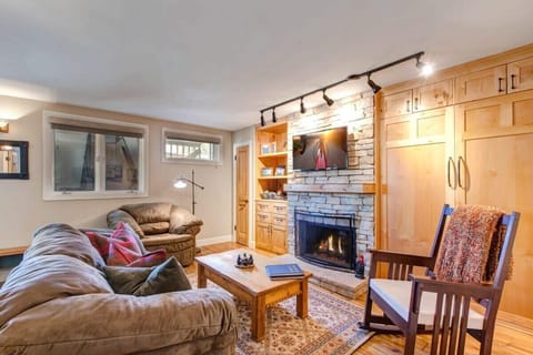 Relax in the family room with a plush sofa, armchair seating, a warm indoor fireplace, and a flat-screen TV