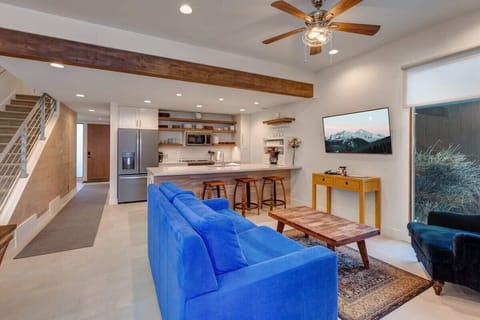 View of the family room, fully-equipped kitchen, front door entrance, and stairs