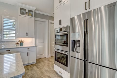 Luxury Fully Equipped Kitchen with Stainless Steel Appliances, Beautiful Quartz Countertops, Spacious Pantry, and Bar Stool Seating for 4