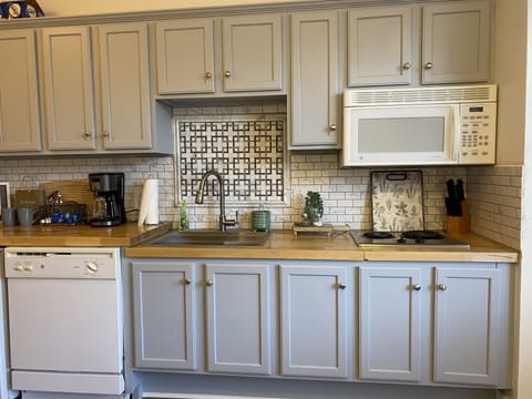 Fully stocked kitchen with stovetop snd microwave.