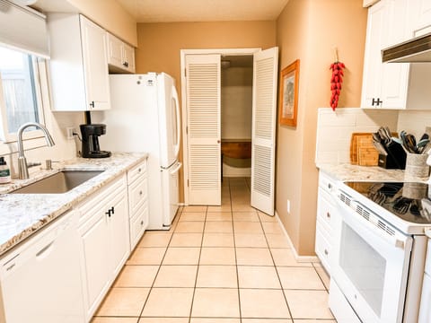 Modern kitchen. Beyond the swinging doors is the washer/dryer and storage space