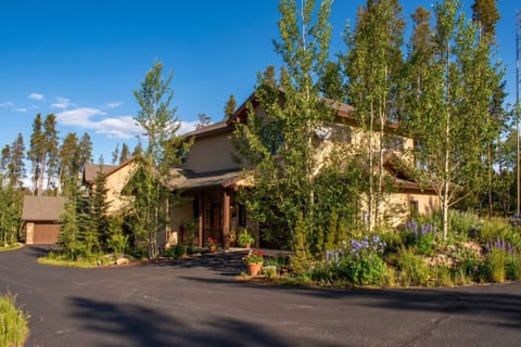A charming mountain retreat nestled among towering aspens and evergreens, with lush gardens and private driveway providing peaceful seclusion in a natural Colorado setting.