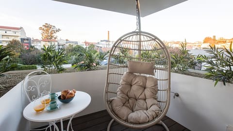 A charming balcony with a hanging chair and a small breakfast table – the perfect spot for slow mornings in the fresh Porto air.

#PortoStay #AirbnbPorto #OutdoorLiving #CozyMoments