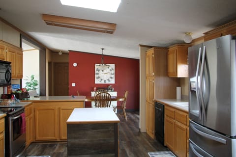 Kitchen with refrigerator,stove and  dishwasher and lots of pots and pants.