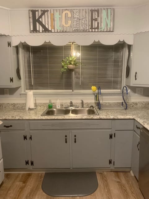 Fully stocked upstairs kitchen with dish soap, sponges, towels, and dish rack