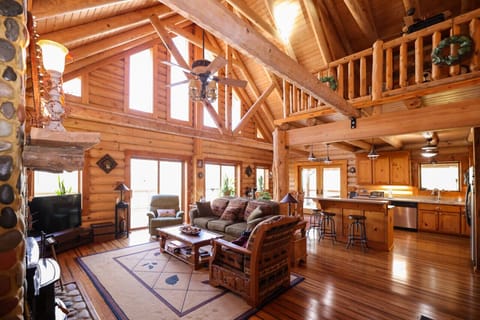 Bask in the warmth of this spacious log cabin’s main living area, featuring an open floor plan, cozy electric fireplace, and Smart TV.