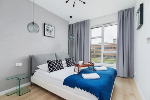 Cozy bedroom with plush white bedding and thoughtful details, including nightstands and wall art. A peaceful space designed for ultimate comfort.