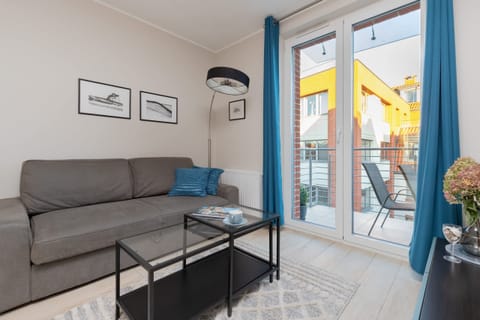 Bright and cozy living room with a comfortable gray sofa, sleek coffee table, and soft lighting. Ideal for relaxing or hosting guests in a modern environment.