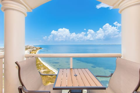 Expansive bay views stretch endlessly from this balcony perch, where turquoise waters meet dramatic cloud formations—a stunning backdrop for the surrounding coastal area.
