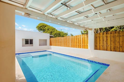 This beautiful private pool area offers privacy and tranquility, surrounded by crisp white walls and a charming wooden fence. Perfect for unwinding in peace and soaking up the sun.