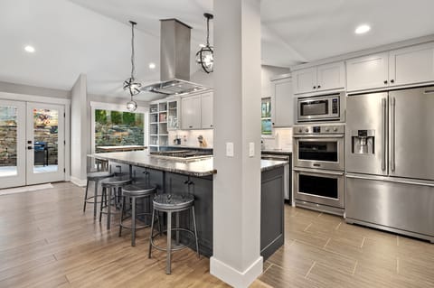 Our bright, open-concept kitchen features a huge island with barstools and high-end appliances.