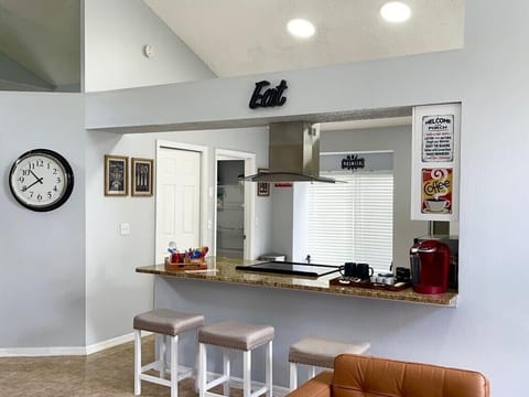 White bar stools to sit and enjoy the kitchen and coffee area.