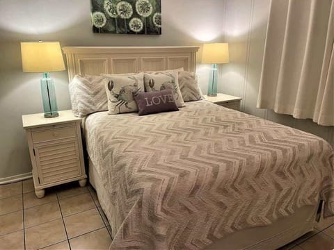 A serene retreat featuring a queen-sized bed with a coastal-patterned duvet.