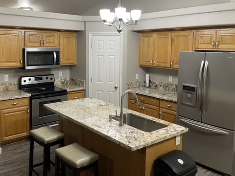 Granite countertops with two bar stools at the island.