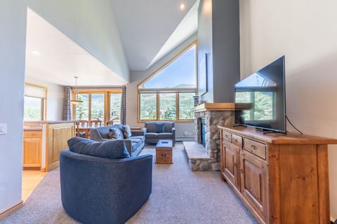 Relax in your spacious living room with stunning mountain views through panoramic windows. Cozy stone fireplace and comfortable seating create the perfect retreat.