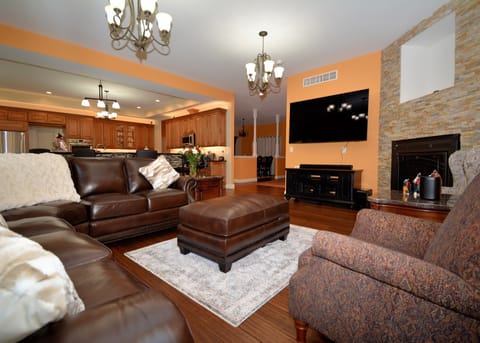Living room with ample seating, 75 inch Smart TV, Sonos, and fireplace 