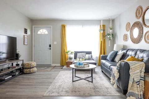 - Bright Airbnb living room with cozy sofa and natural light   - Stylish wall mirrors and bold curtains add modern charm   - Comfortable seating area perfect for relaxing evenings 