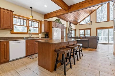 Kitchen with island seating. Just to the right is the 1/2 bathroom & up ahead/right is the living room with fireplace & lots of lounge seating.
