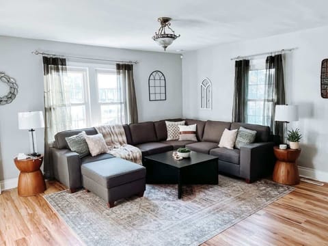 - Spacious living room with sectional sofa and cozy decor   - Large windows with natural light and modern wall art   - Relax in comfort with family seating and smart TV  