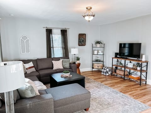 Entertainment area with sofa coffee table and flat TV   - Shelving with accents and natural decor details   - Relax watch shows or enjoy cozy nights in this space