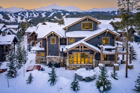 Rear photo of the house with the firepit and hot tub in the shot and views of the ski resort.