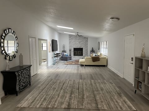 entry area with family room at end where fireplace is & 2 bdrms/1ba off to left