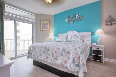 Primary Bedroom: Bright turquoise walls meet beach-inspired decor, with balcony views and a king bed!