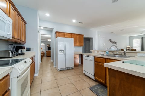 Fully equipped kitchen with ample counter space, full size appliances, and open layout overlooking the living area.
