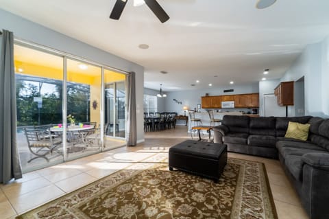 Open living area with comfortable seating, sliding glass doors to the patio, and clear view into the kitchen and dining space.