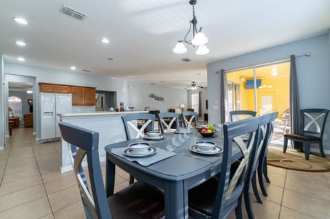 Dining area with table seating for 6, open layout, and sliding doors leading to the pool area.