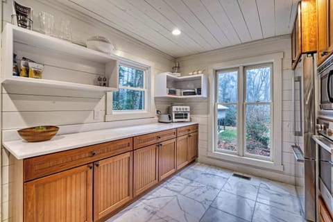 bright kitchen with wooden cabinets and large windows overlooking the garden