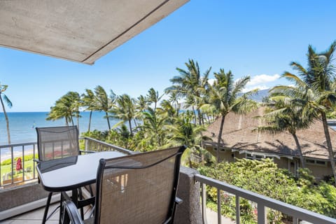 Oceanfront balcony with swaying palms framing endless sea views—where your morning coffee tastes better and sunset moments feel infinite.