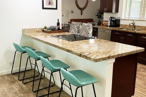 open kitchen with bar seating for 4 and seating for 8 at dining table