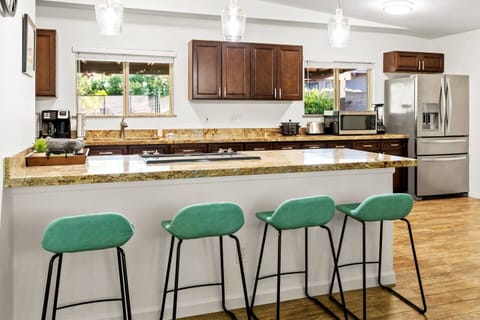Spacious chef's kitchen with seating for 4 at the bar and TV.