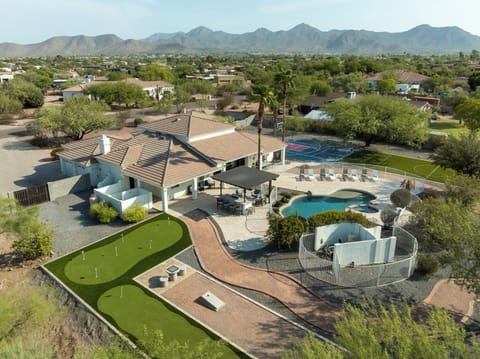 Sunset drone view highlighting the property's incredible amenities, including the pool, sports court, and sprawling 1.27-acre lot.