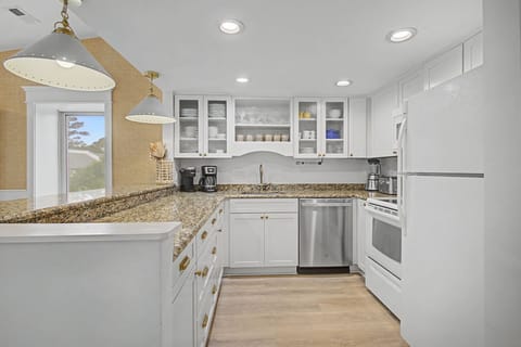 You'll love preparing meals in this bright, fully-equipped kitchen with granite countertops, stainless appliances, and pendant lighting.