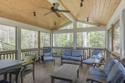 A serene screened porch that provides a peaceful view of Flat Creek, allowing guests to enjoy the natural surroundings comfortably