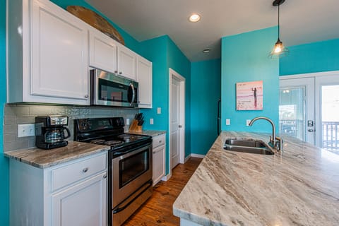 Upstairs kitchen has stainless appliances and a pantry