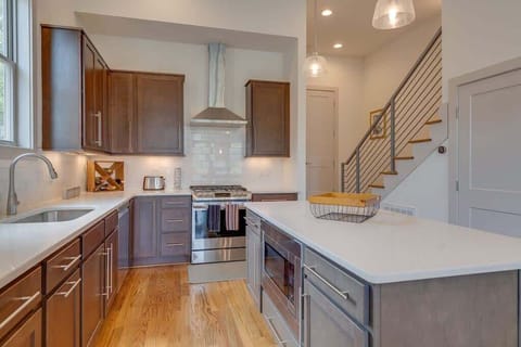 Modern kitchen featuring wooden cabinetry, stainless appliances, and a central island.