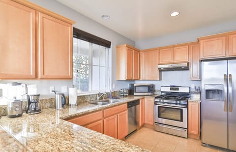 The kitchen is equipped with stainless steel appliances and cookware