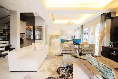Tastefully furnished living area with a 5-seater sofa set and TWO arm chairs.