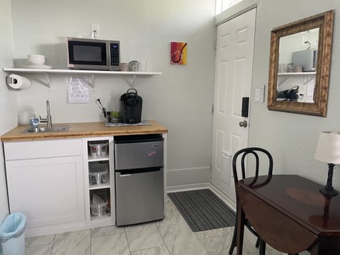 Kitchenette with dishes, cups, silverware, kitchen towels and kitchen tools.
