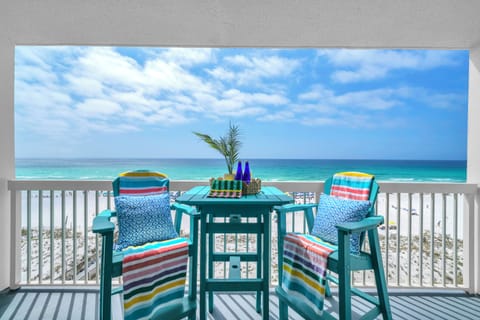 Sip your morning coffee on your private beachfront balcony, where colorful striped cushions and tropical touches frame endless turquoise waters.