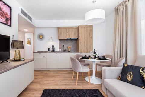 A wider perspective of a cosy and stylish space that combines a seating area with a dining area. In the background is the kitchenette.