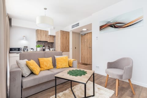 A bright, cosy living room space where the seating area is combined with the dining area. A decorative black carpet lies on the floor.