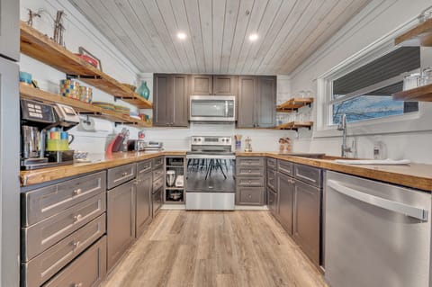Spacious kitchen with open shelving and every modern convenience. 
