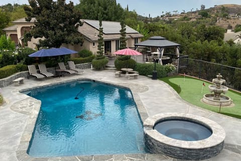 Backyard area with pool, spa, private deck area with pergola and 3 hole putting green. This shows the back of the guest house.