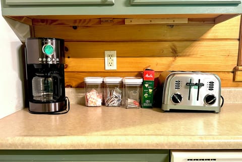 Coffee maker with Folgers coffee, cream, sugar. Teas and electric kettle